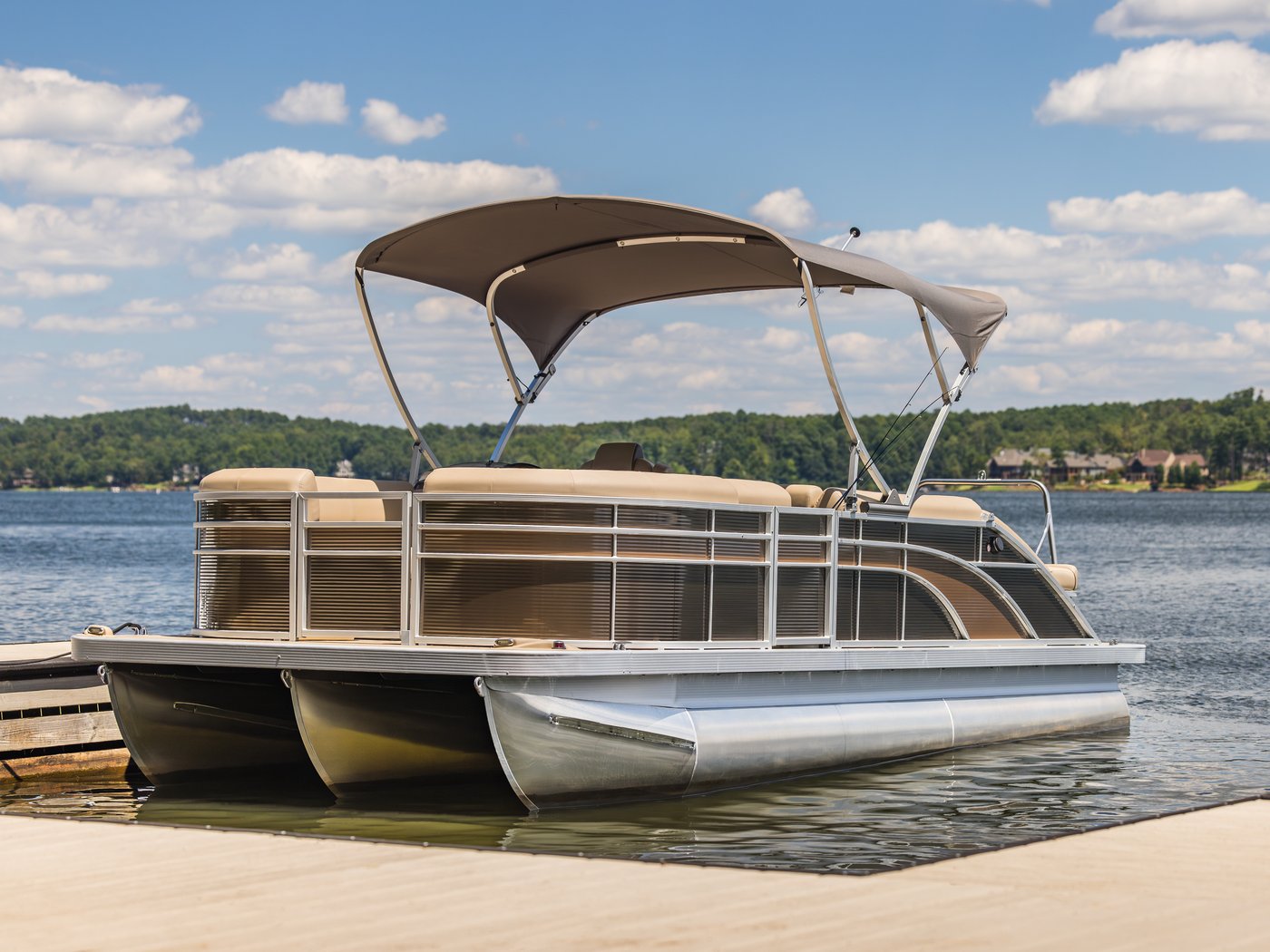 Pontoon boat with bimini on a lake dock