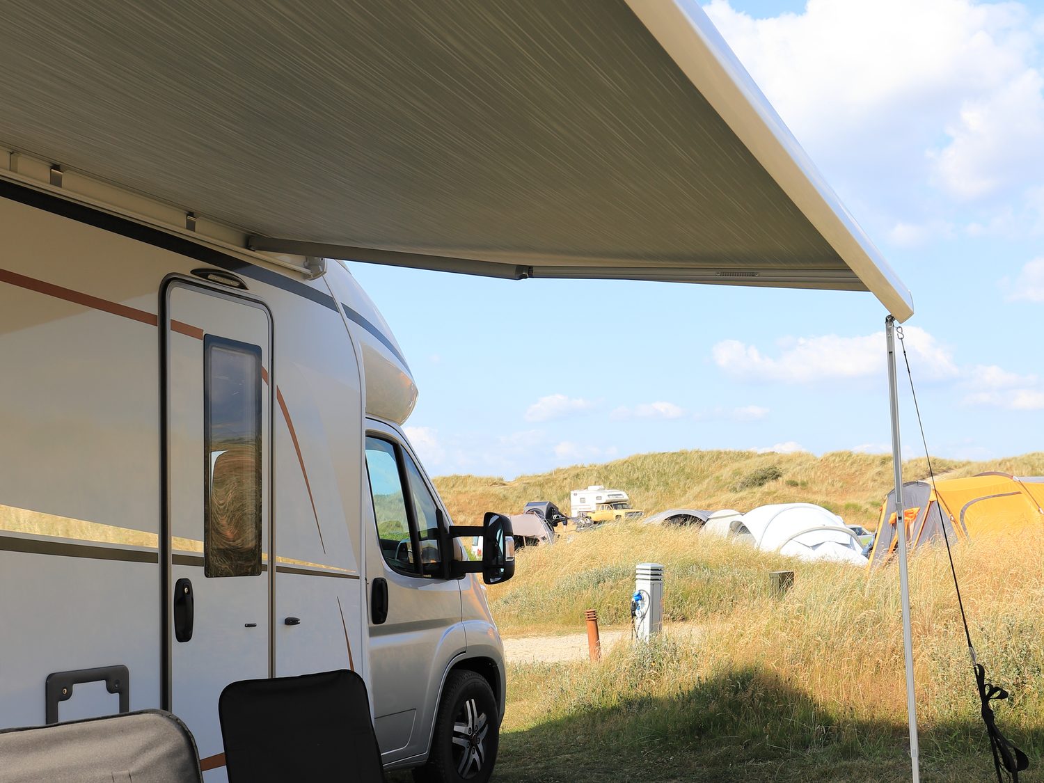 RV parked beneath an awning at a campsite