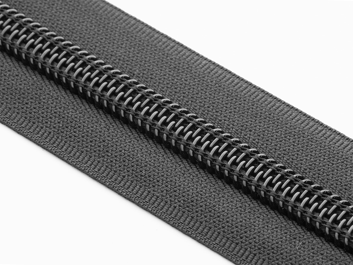 Close-up of black coil zipper on black tape