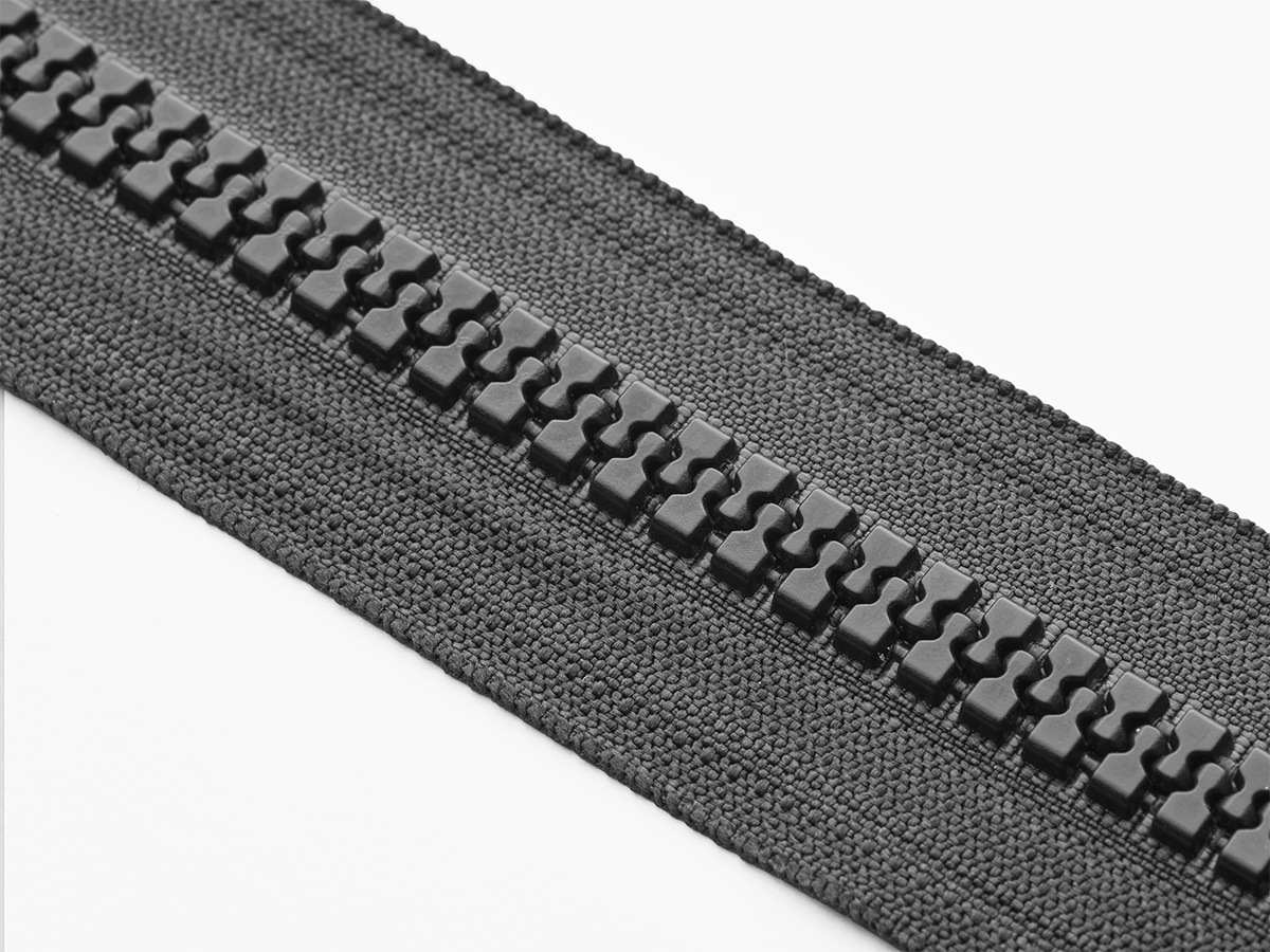Close-up of black molded zipper teeth on black tape